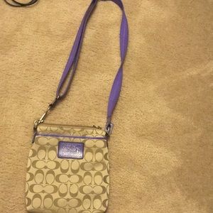 A coach messenger bag with purple straps.😃💜